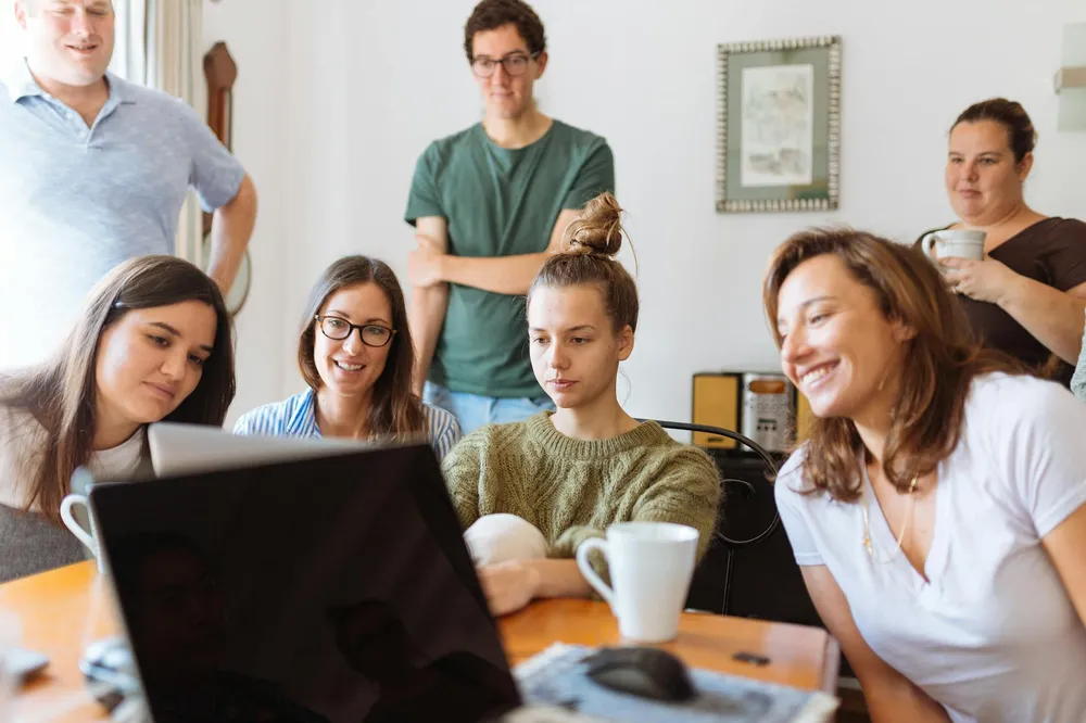 A group of young people learning together around a laptop